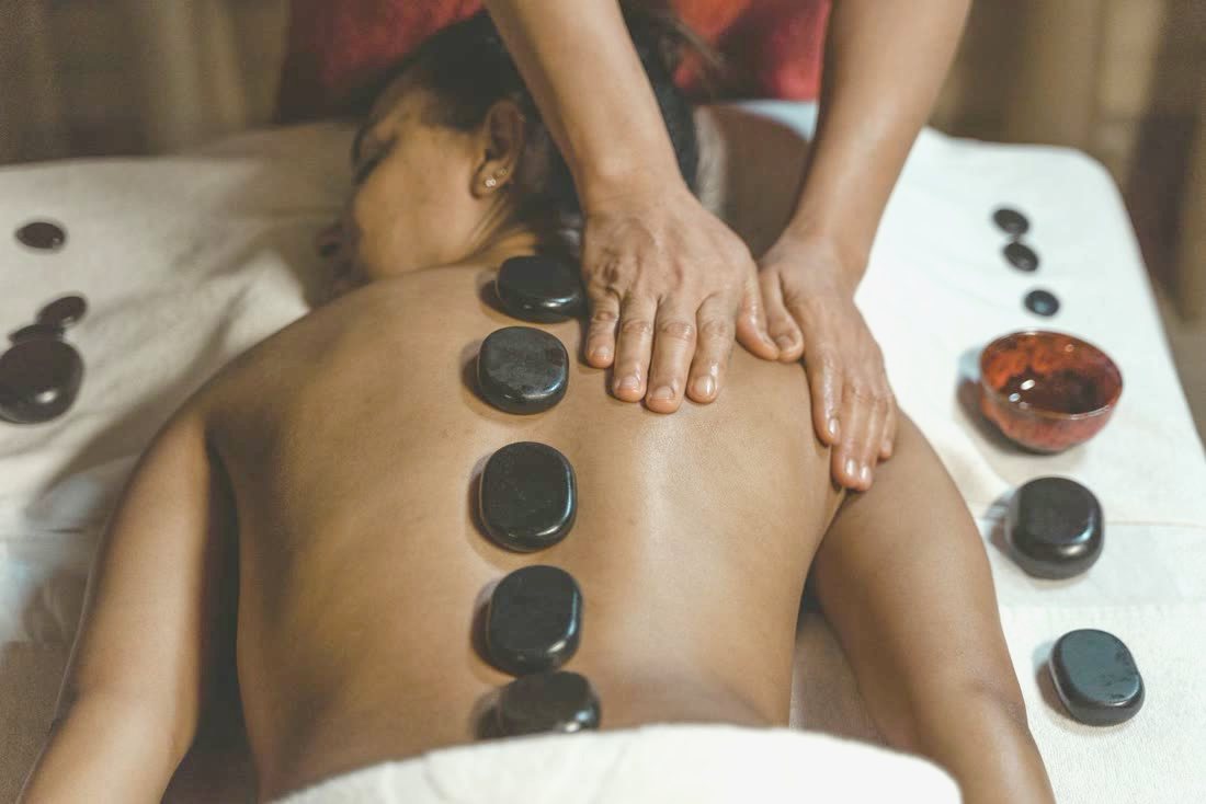 Massage du dos aux huiles chaudes, pierres posées le long de la colonne — le Ku Nye tibétain
